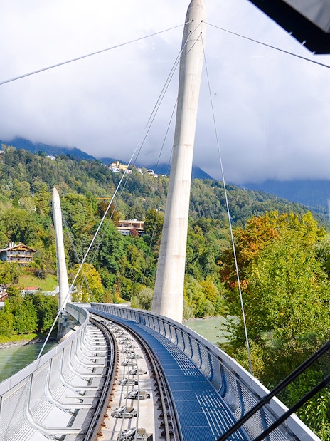 Hungerburg Funicular station view with tracks and lush green hills in Innsbruck, Austria.
