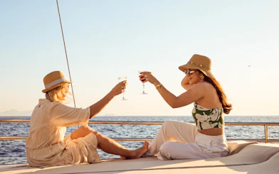 Women toasting with wine on a sunset cruise along Athens Riviera.