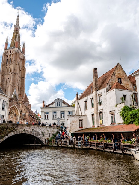 Scenic canal in Bruges, Belgium with Church of Our Lady in the background.