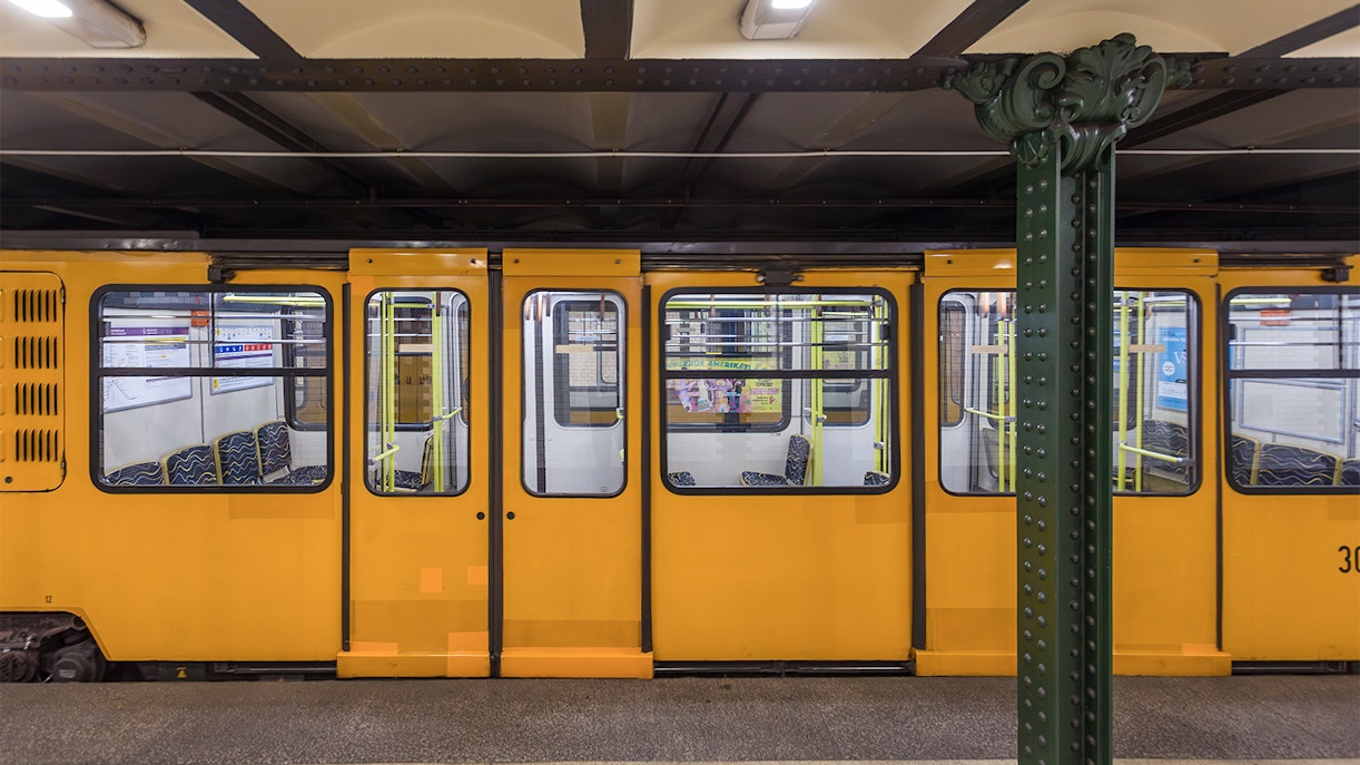 Yellow metro train at a station platform.