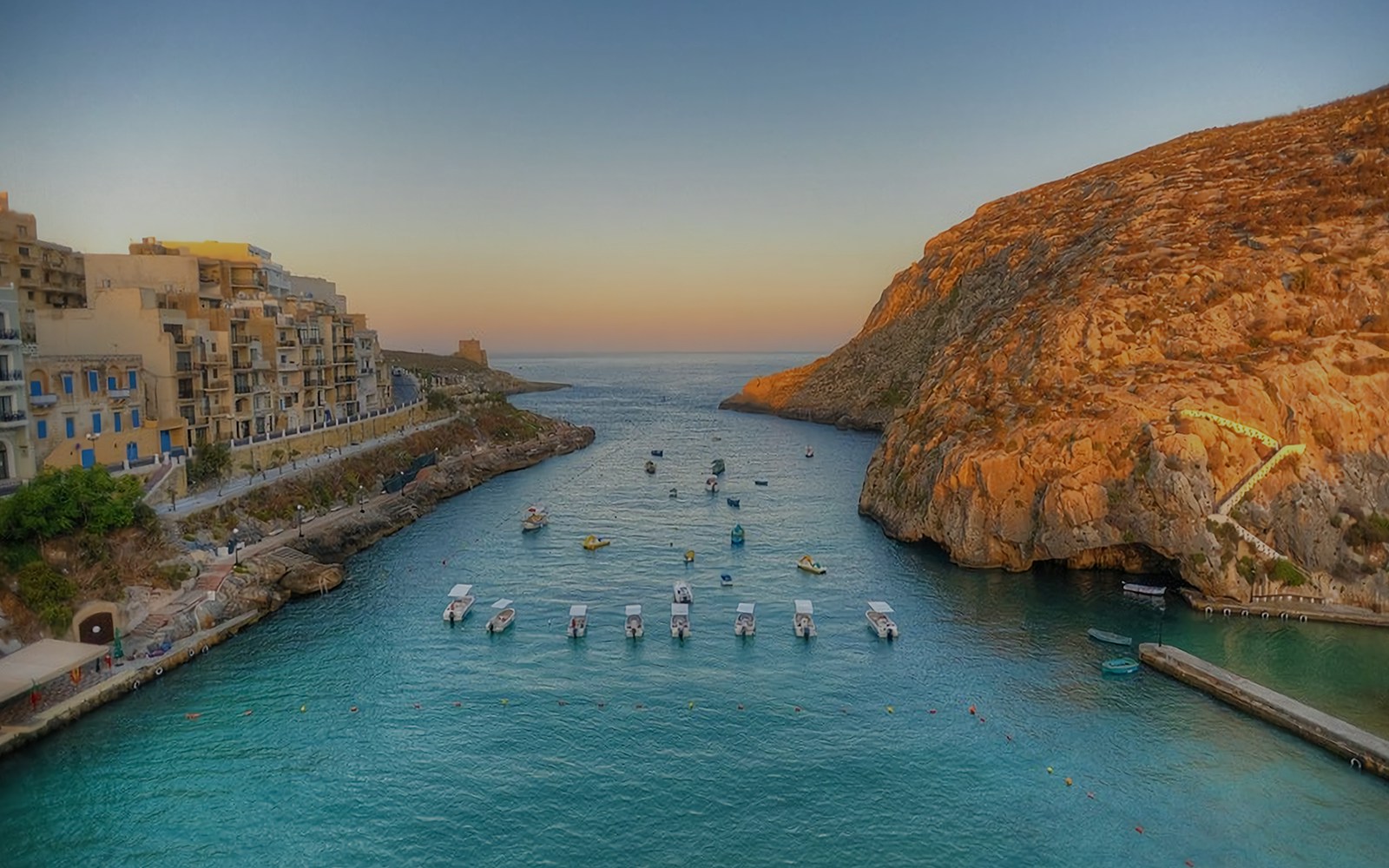 Xlendi Bay coastline with clear blue waters and rocky cliffs in Gozo, near Malta.
