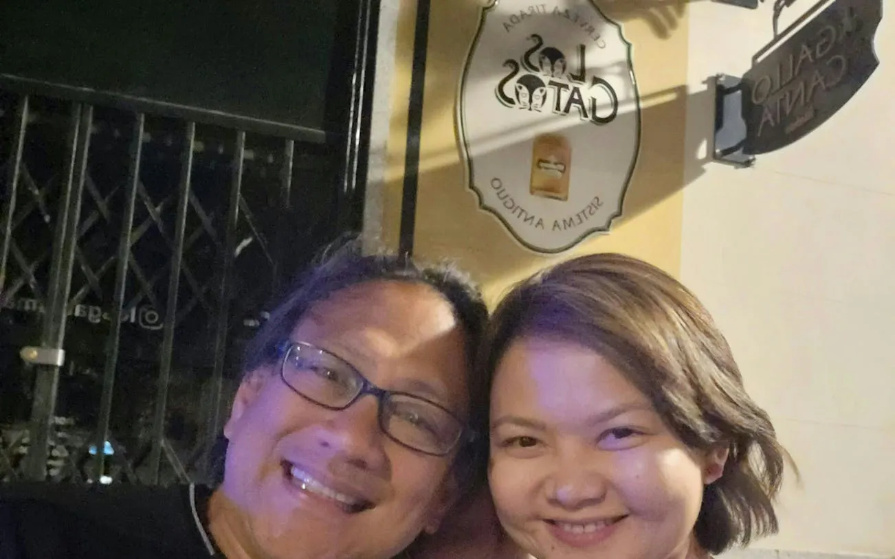 Two people smiling in front of Los Gatos sign during Ghosts of Madrid tour.