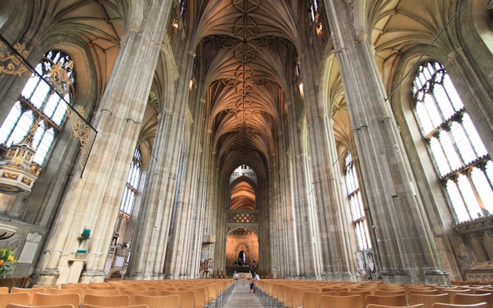 Interior of Canterbury Cathedral with vaulted ceilings and stained glass windows, part of the Canterbury and Dover tour.