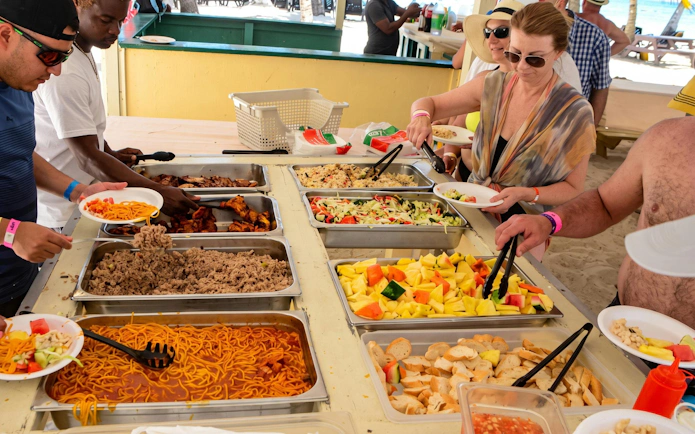 Buffet spread with fruits, salads, and meats on Saona Island catamaran tour from Punta Cana.