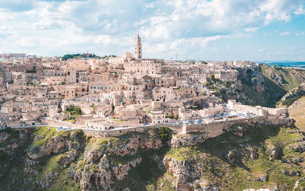 Matera ancient cityscape with stone buildings and church tower, Italy.