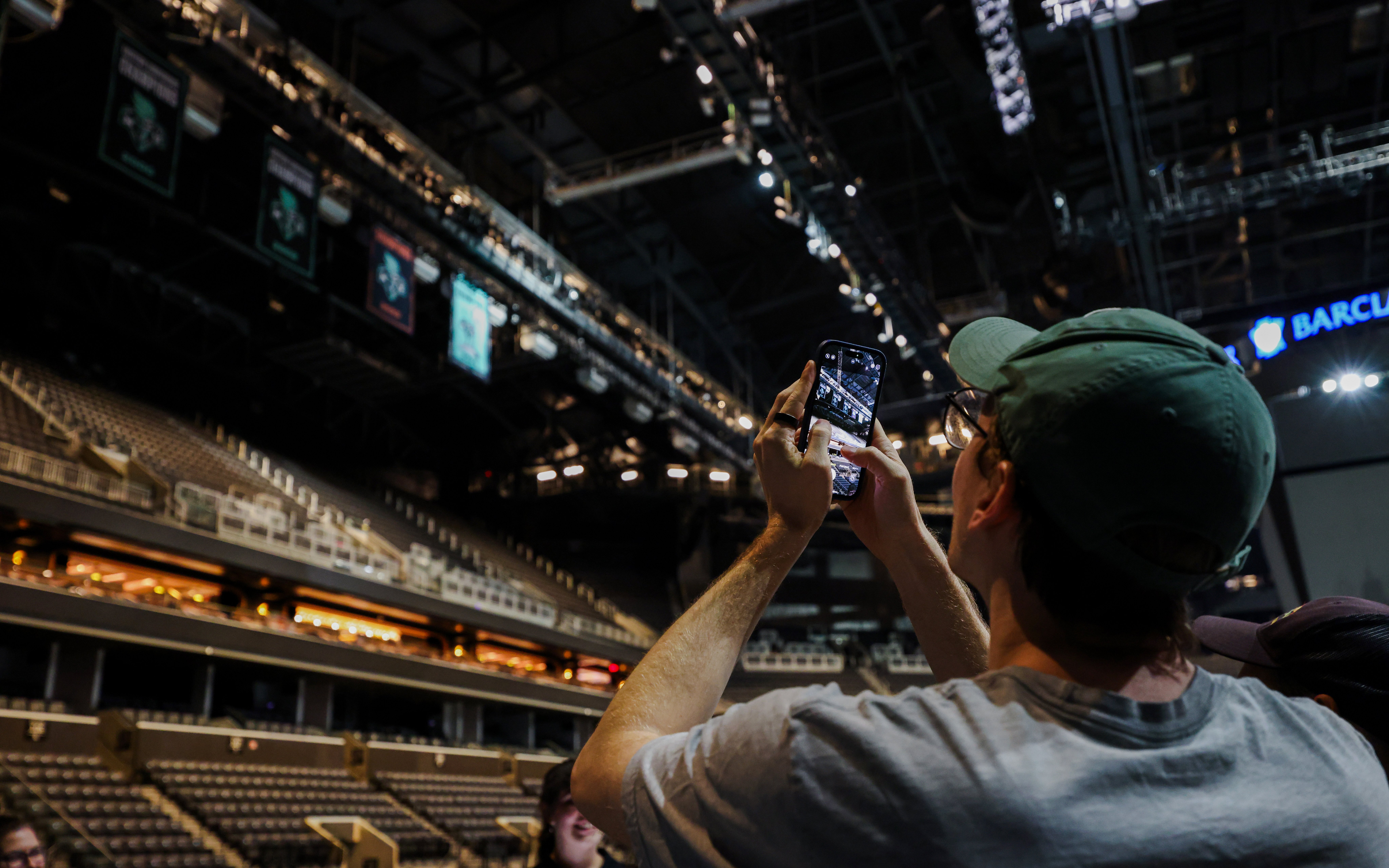 Person taking photo inside Barclays Center during guided tour, New York.