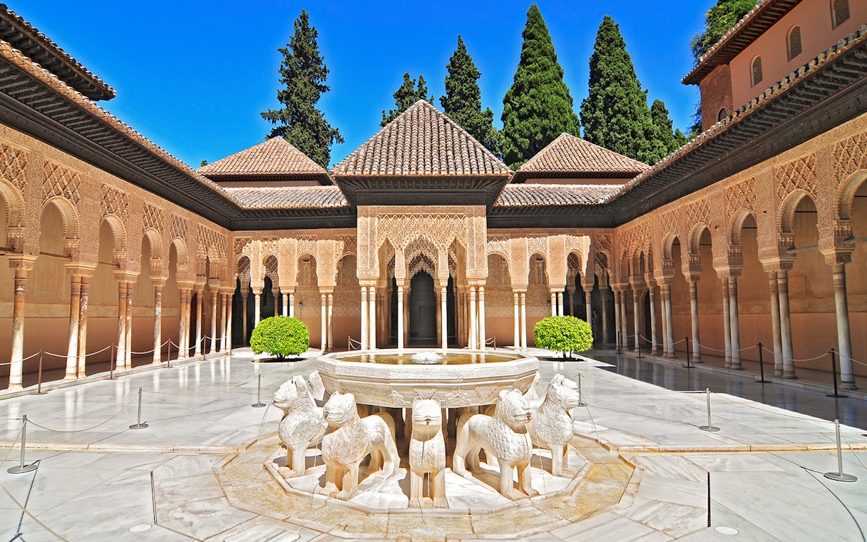 Courtyard of the Lions at the Alhambra in Granada, featuring ornate arches and lion fountain.