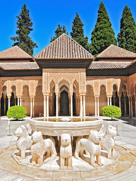 Courtyard of the Lions at the Alhambra in Granada, featuring ornate arches and lion fountain.