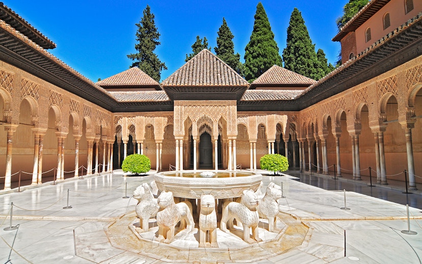 Courtyard of the Lions at the Alhambra in Granada, featuring ornate arches and lion fountain.