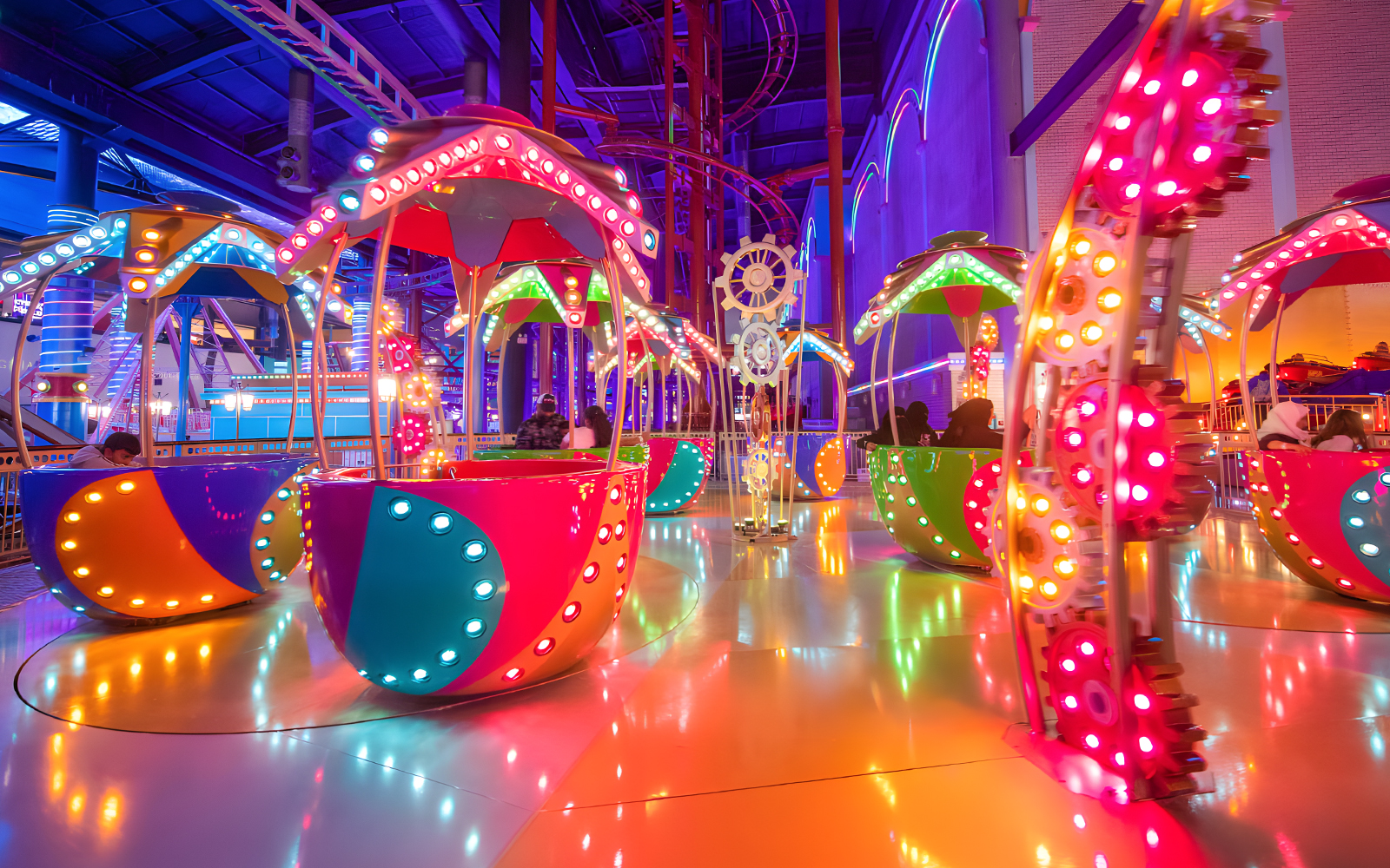 Colorful rides at Genting Skytropolis Indoor Theme Park, Malaysia, with vibrant lights and gears.