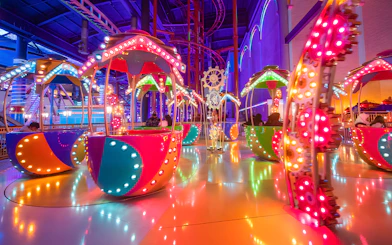 Colorful rides at Genting Skytropolis Indoor Theme Park, Malaysia, with vibrant lights and gears.