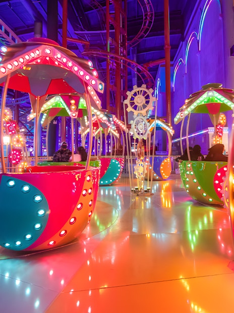 Colorful rides at Genting Skytropolis Indoor Theme Park, Malaysia, with vibrant lights and gears.