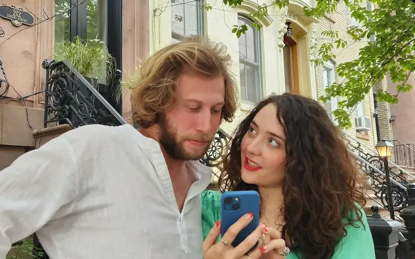 Couple using phone for Midtown Manhattan Greek Gods Adventure game in New York street.