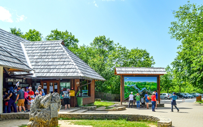 Visitors at Plitvice Lakes entrance from Zadar, viewing a large map display.