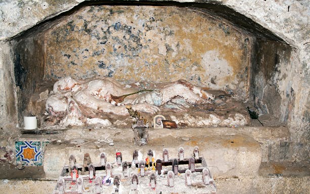 Ancient tomb with religious artifacts in Catacombs of San Gennaro, Naples.