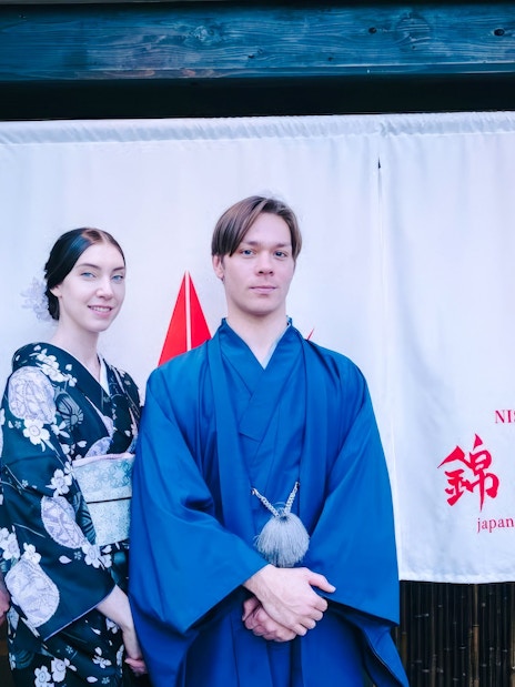 Tourists in traditional attire outside a Japanese tea ceremony venue.