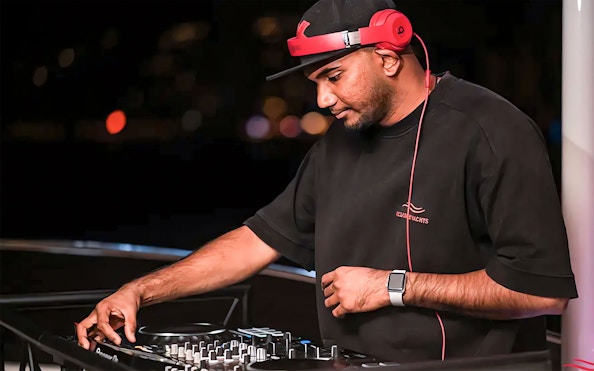 DJ performing on a party yacht cruise at night.
