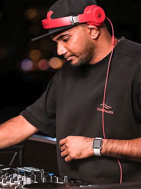 DJ performing on a party yacht cruise at night.