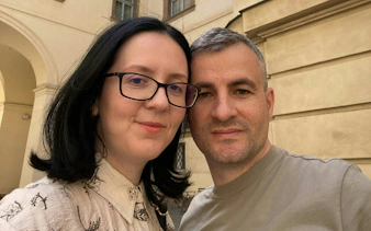 I don't know who these people are, but here's the alt text:
"Couple exploring Prague courtyard during self-guided city game.