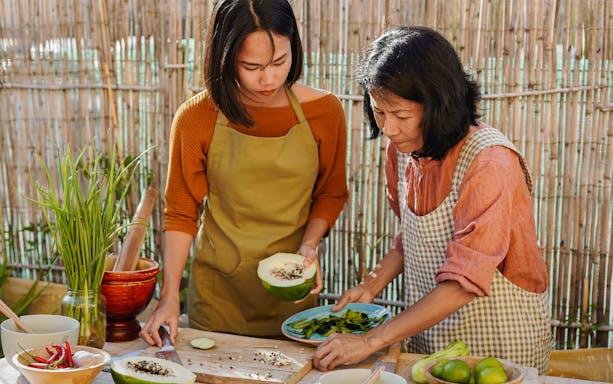 Two people preparing Thai papaya salad during a guided food tour.