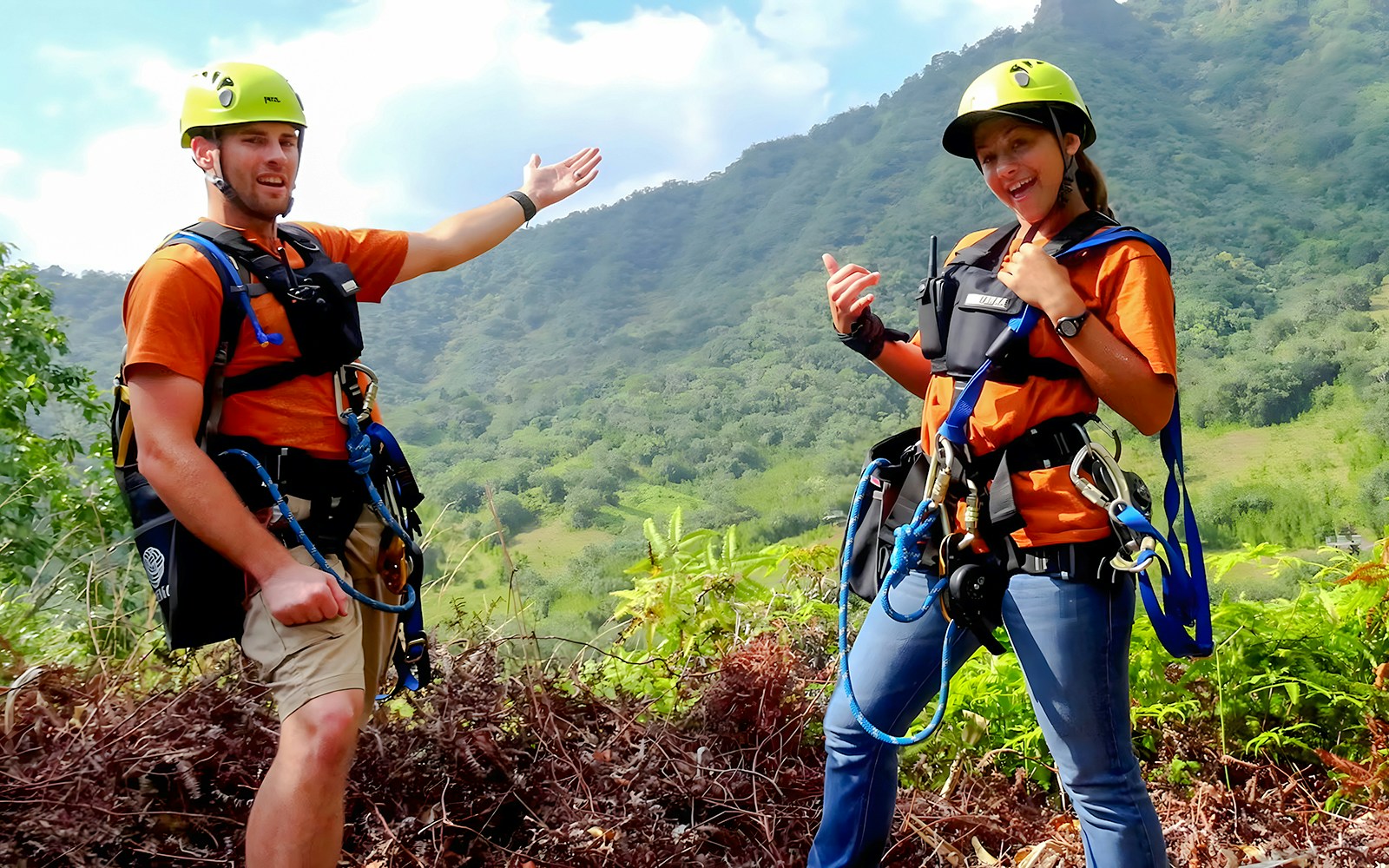 Zipline guides at Kualoa Ranch, Hawaii, with lush mountain backdrop.