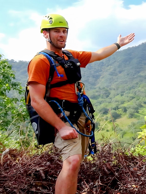 Zipline guides at Kualoa Ranch, Hawaii, with lush mountain backdrop.
