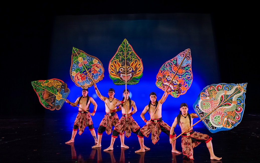 Performers at Devdan Show in Bali holding colorful shields, showcasing Indonesian dance.