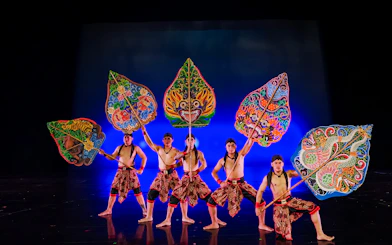 Performers at Devdan Show in Bali holding colorful shields, showcasing Indonesian dance.