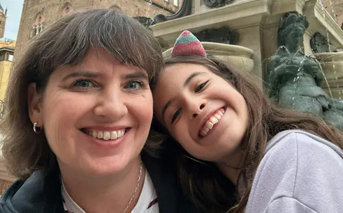 Smiling visitors at the Fountain of Neptune, Bologna, during the city exploration game.
