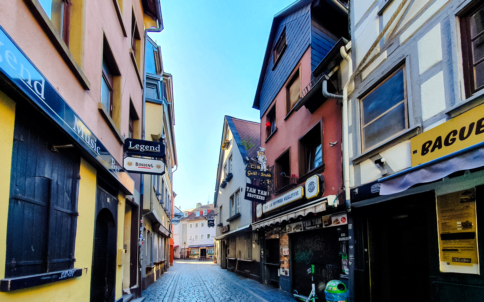 Cobbled street in Alt-Sachsenhausen, Frankfurt, lined with traditional buildings and bars.