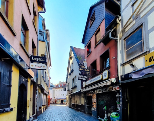 Cobbled street in Alt-Sachsenhausen, Frankfurt, lined with traditional buildings and bars.