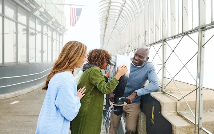 Visitors enjoying the view from the Empire State Building observatory in NYC.