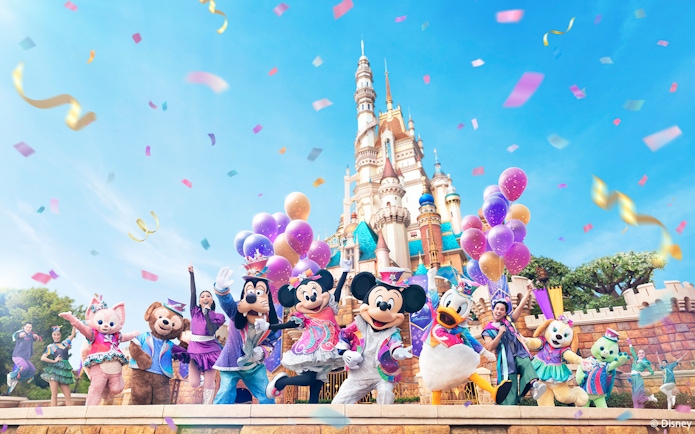 Disney characters celebrating 20th anniversary at Hong Kong Disneyland with castle backdrop.