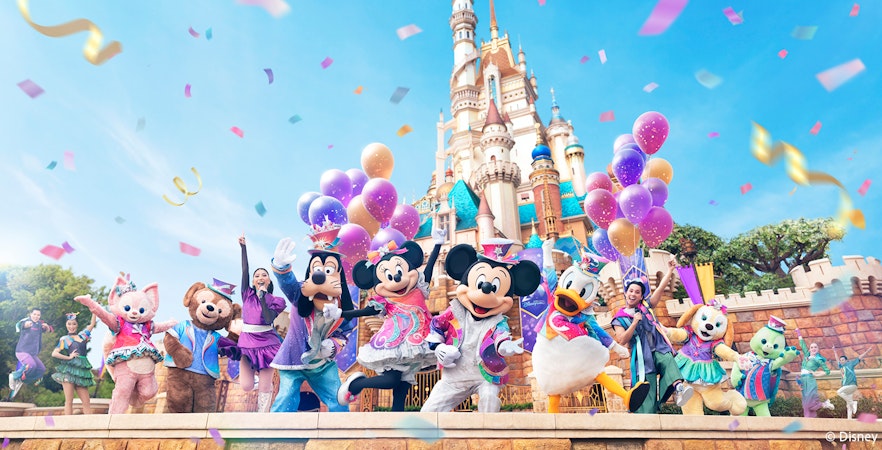Disney characters celebrating 20th anniversary at Hong Kong Disneyland with castle backdrop.