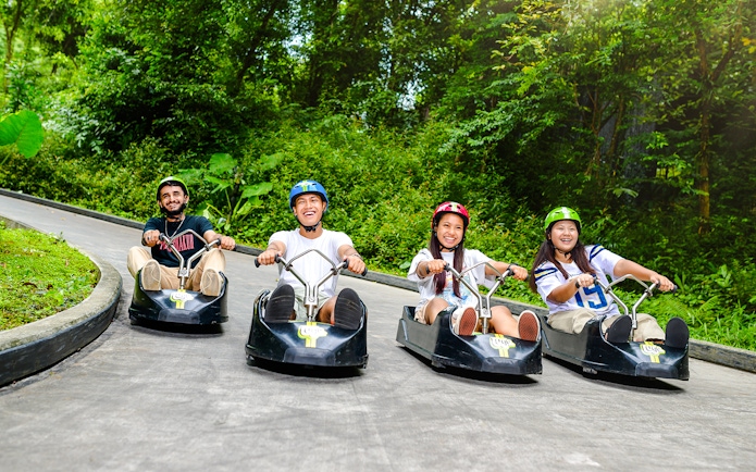 Friends enjoying a ride on the Skyline Luge track in Singapore.