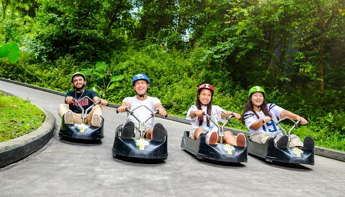 Friends enjoying a ride on the Skyline Luge track in Singapore.