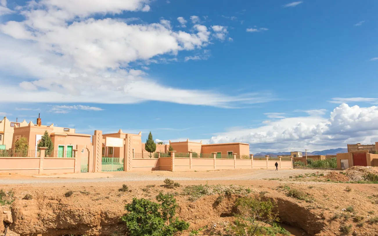 Adobe-style buildings under a blue sky on the Marrakech to Fes Sahara tour route.