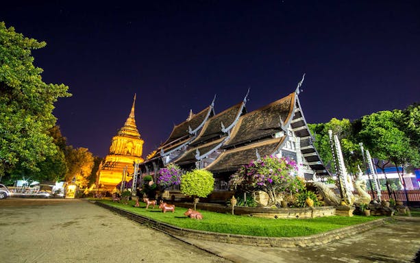 Chiang Mai temple illuminated at night during a bike tour.