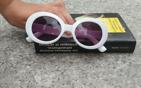 Sunglasses resting on a book on a stone surface in Bed-Stuy, Brooklyn.
