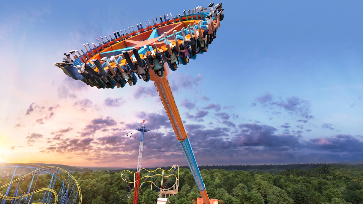 Swing ride at Six Flags Mexico against a sunset sky.