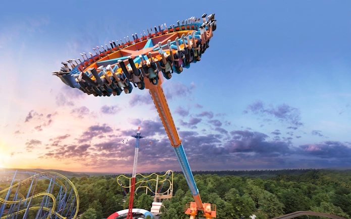 Swing ride at Six Flags Mexico against a sunset sky.