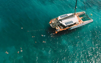 Catamaran with swimmers in clear waters during Rosario Islands cruise.