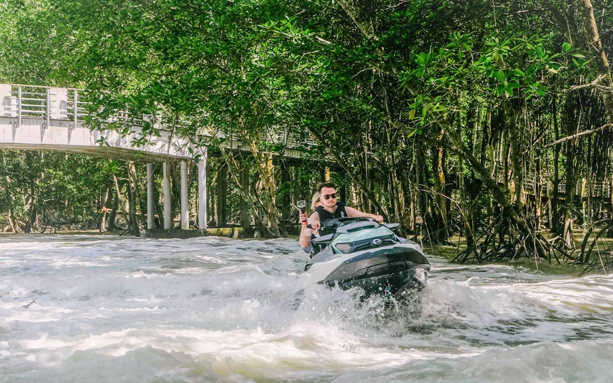 Jet ski navigating through mangroves in Langkawi's UNESCO Kilim Geopark.
