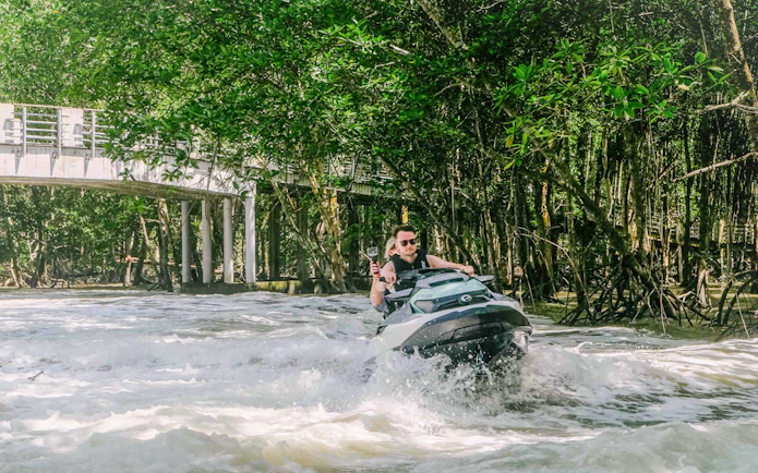 Jet ski navigating through mangroves in Langkawi's UNESCO Kilim Geopark.