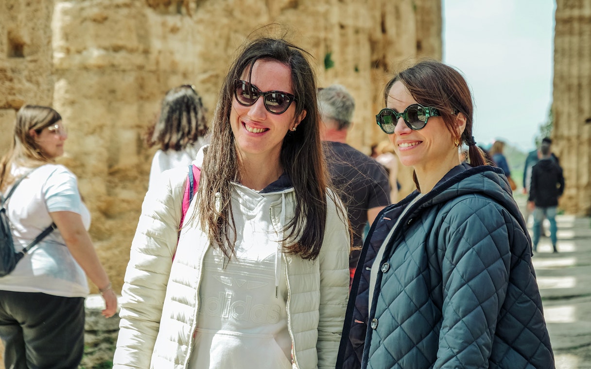 Visitors enjoying a guided tour at Paestum Archaeological Site in Italy.