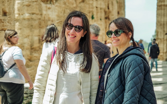 Visitors enjoying a guided tour at Paestum Archaeological Site in Italy.