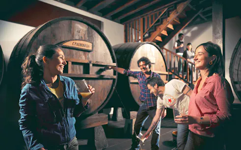 Visitors enjoying cider tasting at a traditional cider house near San Sebastian.