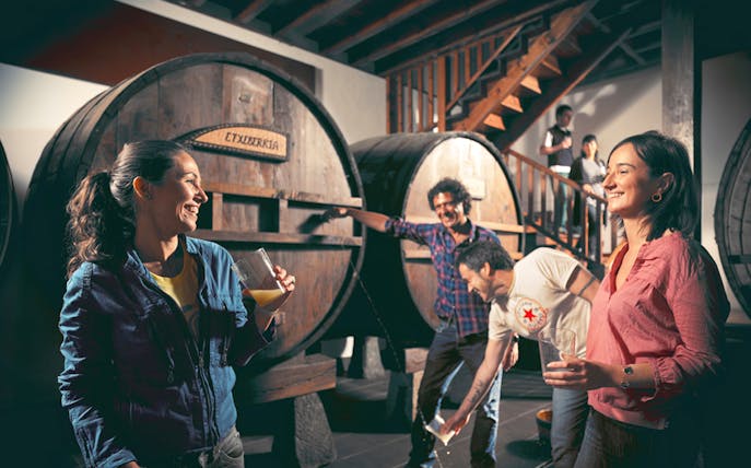 Visitors enjoying cider tasting at a traditional cider house near San Sebastian.