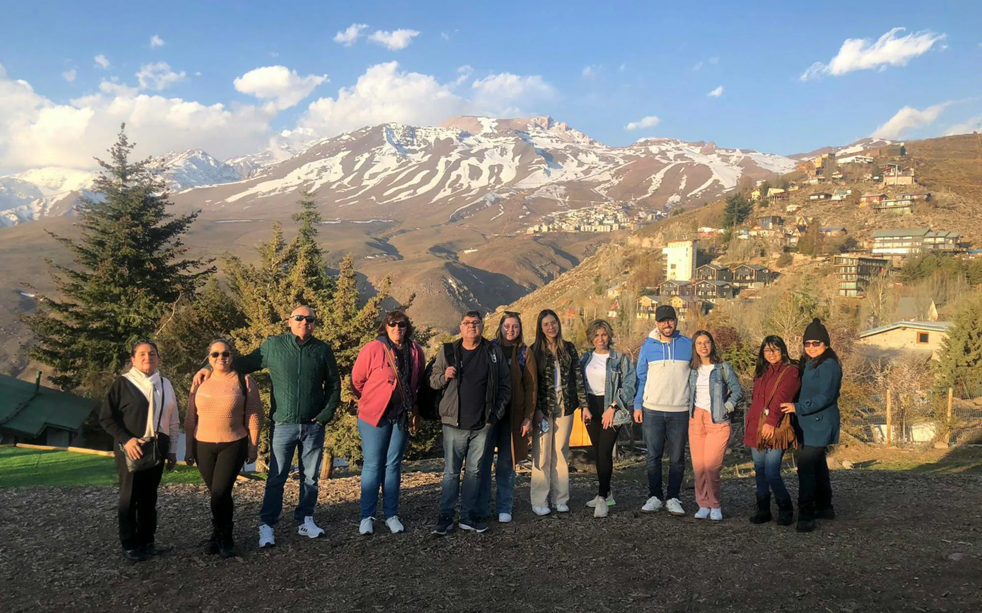 Group of people standing in front of the Andes Mountains in Chile.