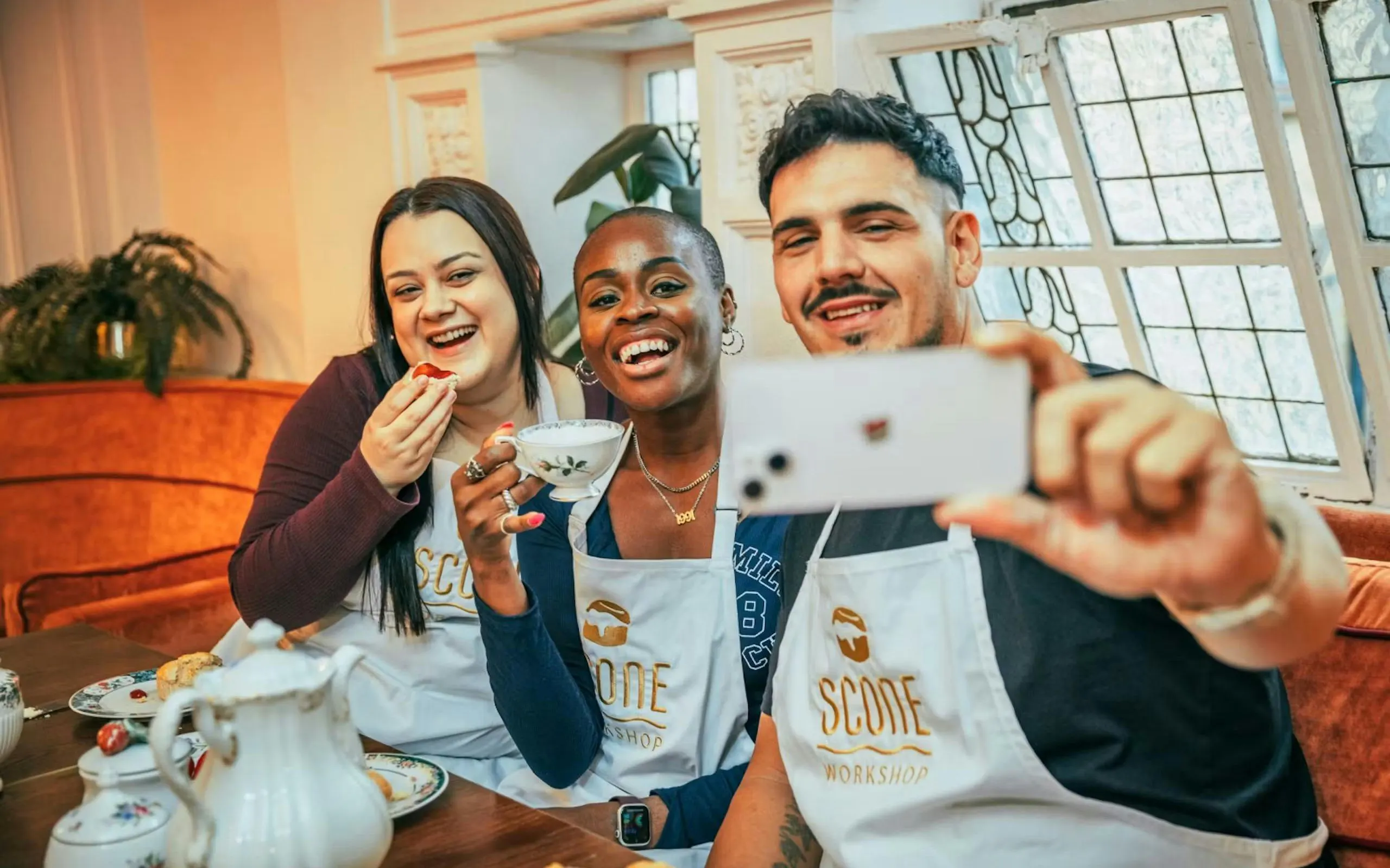 Participants enjoying a scone-making workshop in London with tea.
